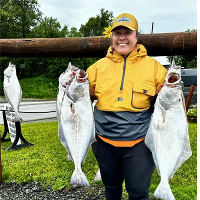 Dr. Tangiilima Ripley smiling while holding 2 giant fish.